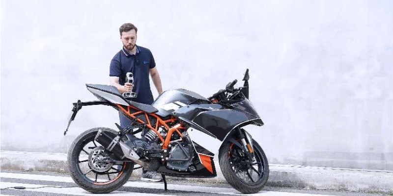 A man scanning a motorbike with the iReal M3 3D scanning device